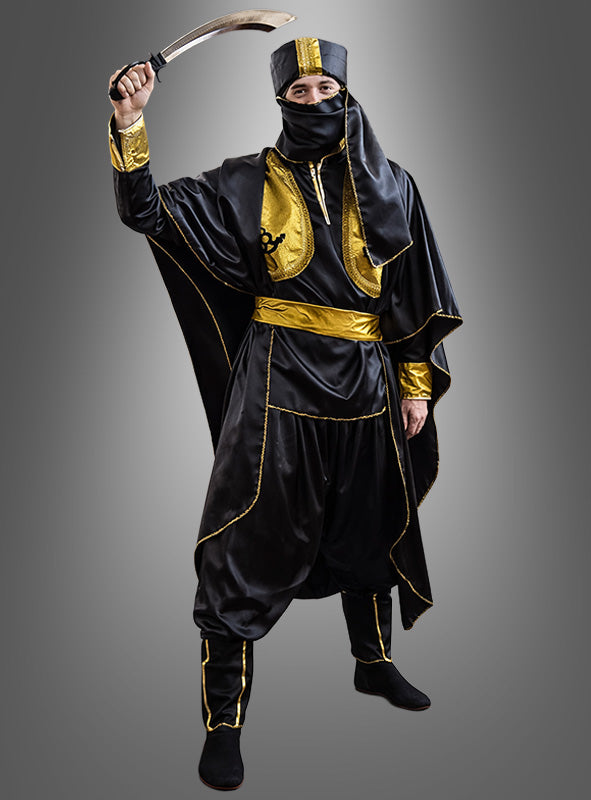 Eine Person, die das Tuareg-Orientkostüm „Ölscheich 1001 Nacht“ in Schwarz und Gold trägt, hält ein Krummschwert über den Kopf, während sie eine dazu passende Kopfbedeckung und Maske trägt und vor einem grauen Hintergrund mit Farbverlauf steht.