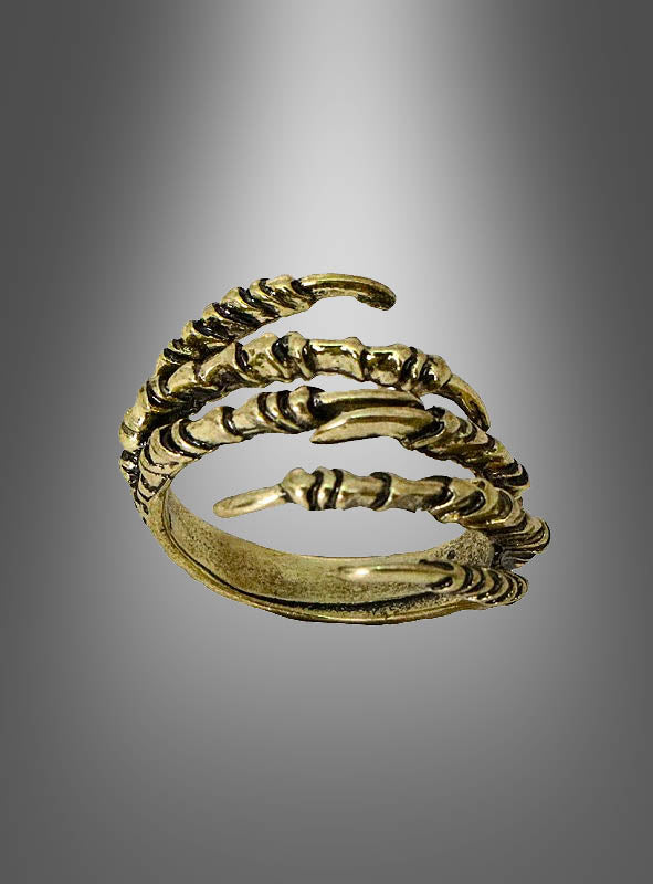 Ein goldener Ring in Form einer Skeletthand, die wie eine Klaue geformt ist und sich mit drei gebogenen, gelenkigen Segmenten um den Finger schlingt; er erinnert an einen Skeletthand-Ring und eignet sich perfekt als Halloween-Schmuck, vor einem grauen Hintergrund mit Farbverlauf.