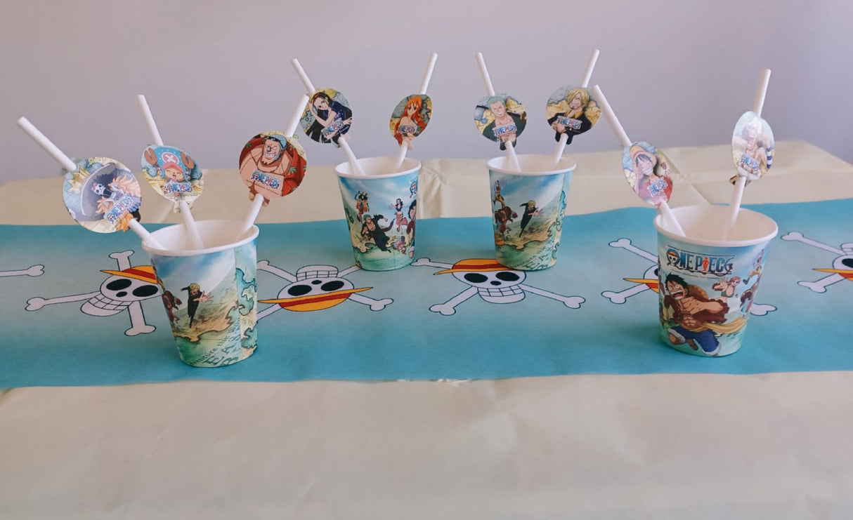 Fünf „One Piece“-Pappbecher (250 ml) mit Strohhalmen stehen auf einem Tisch – perfekt für jede Anime-Party oder jeden Kindergeburtstag. Der Tisch ist mit einem blauen Tischläufer verziert, auf dem Piratentotenköpfe und gekreuzte Knochen aus „One Piece“ abgebildet sind, was für eine abenteuerliche Atmosphäre sorgt.