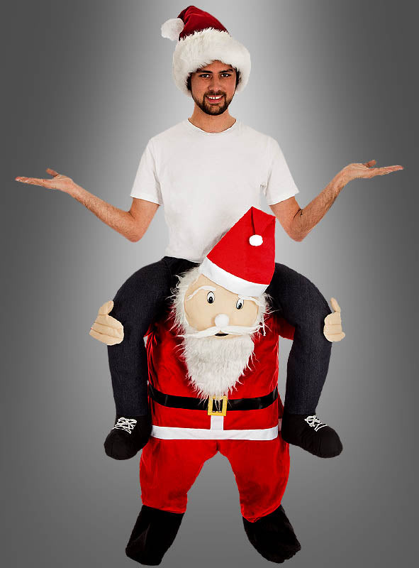 Vor einem schlichten grauen Hintergrund ist ein Mann mit einer Weihnachtsmannmütze und einem weißen Hemd zu sehen, der offenbar auf den Schultern des Weihnachtsmanns reitet und ein „2. Wahl Huckepackkostüm Weihnachtsmann“-Kostüm trägt.