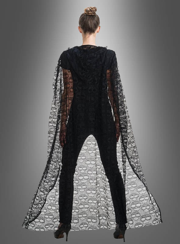 Eine Person steht mit dem Rücken zur Kamera und trägt den „Umhang aus Spitze 140 cm mit Totenköpfen“ – einen eleganten, transparenten schwarzen Umhang, der mit Totenkopfmotiven verziert ist – über einem schwarzen Outfit und High Heels, vor einem grauen Hintergrund mit Farbverlauf.