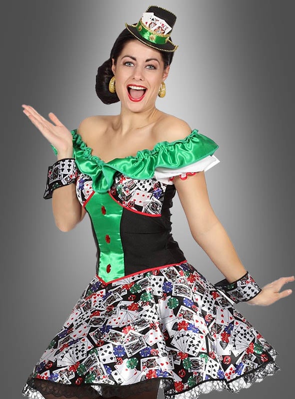 Eine Frau in einem Kostüm im Casino-Stil mit Spielkarten, grünem und schwarzem Stoff, passenden Manschetten und dem „Casino Mini Hut am Haarreif“ – einem eleganten Damenaccessoire, das mit Karten verziert ist – lächelt und posiert vor einem grauen Hintergrund, um den perfekten Las-Vegas-Kostüm-Look zu erzielen.