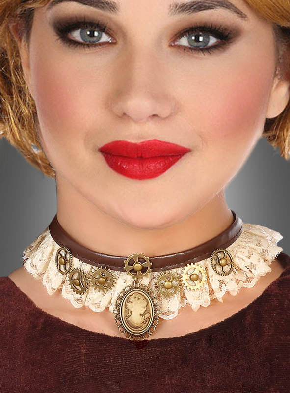 Eine Frau präsentiert den Steampunk-Halsschmuck – ein braun-weißer Spitzen-Choker, verziert mit goldenen Zahnrädern und einem Kameo-Anhänger –, kombiniert mit rotem Lippenstift und einem braunen Oberteil, vor einem grauen Hintergrund.