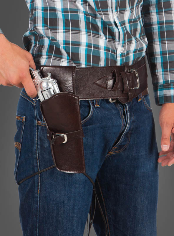 Eine Person, die ein kariertes Hemd und Jeans trägt, hält einen silbernen Revolver in einem braunen Lederholster „Cowboy Pistolenholster und Gürtel 84–100 cm“, das an ihrem Gürtel befestigt ist.