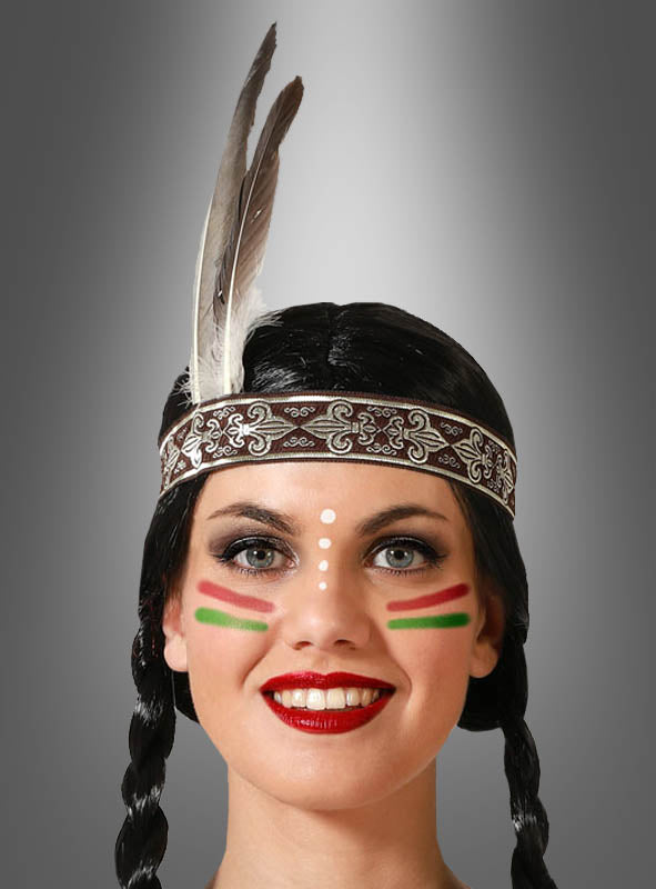 Eine Person mit geflochtenen Haaren trägt das „Indianer-Haarband Graue Feder“ mit einer grauen Feder und Gesichtsbemalung mit weißen Punkten sowie grünen und roten Streifen, während sie vor einem grauen Hintergrund mit Farbverlauf in die Kamera lächelt – und damit die Essenz eines Indianer-Kostüms perfekt verkörpert.