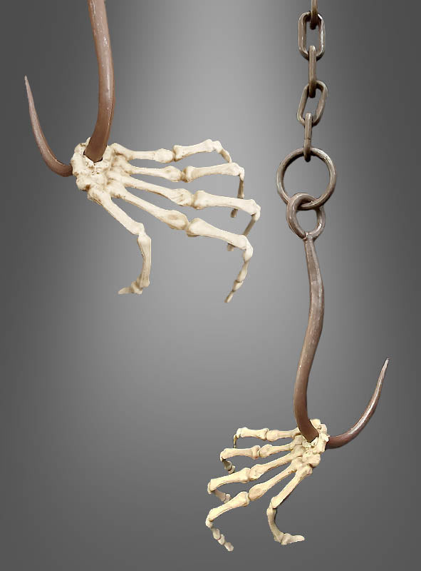 Zwei große Metallhaken sind in naturgetreue Skeletthände eingelassen, wodurch sich die „Lebensgroße Skeletthand am Haken mit Kette“ ideal für Ihre gruselige Dekoration eignet. Eine Hand ist an einer stabilen Aufhängekette befestigt, beide sind vor einem schlichten grauen Hintergrund angeordnet – perfekt als auffälliges Halloween-Dekorationselement.