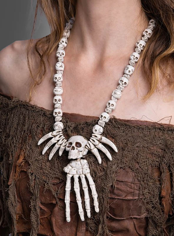 Eine Person, die eine „Skeletthand Totenkopf“-Kette trägt, kombiniert mit einem zerfetzten, erdfarbenen Oberteil mit Struktur.