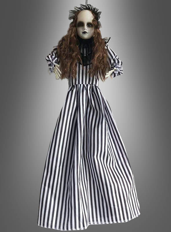 Wir stellen vor: die Horror-Puppe als Halloween-Dekoration, 50 cm: Diese Puppe hat langes braunes Haar, ein blasses Gesicht und dunkle Lippen. Sie trägt ein schwarz-weiß gestreiftes Kleid mit einem passenden schwarzen Haaraccessoire – damit ist sie die perfekte gruselige Geisterdekoration oder Horror-Puppe für Ihre Halloween-Dekoration.
