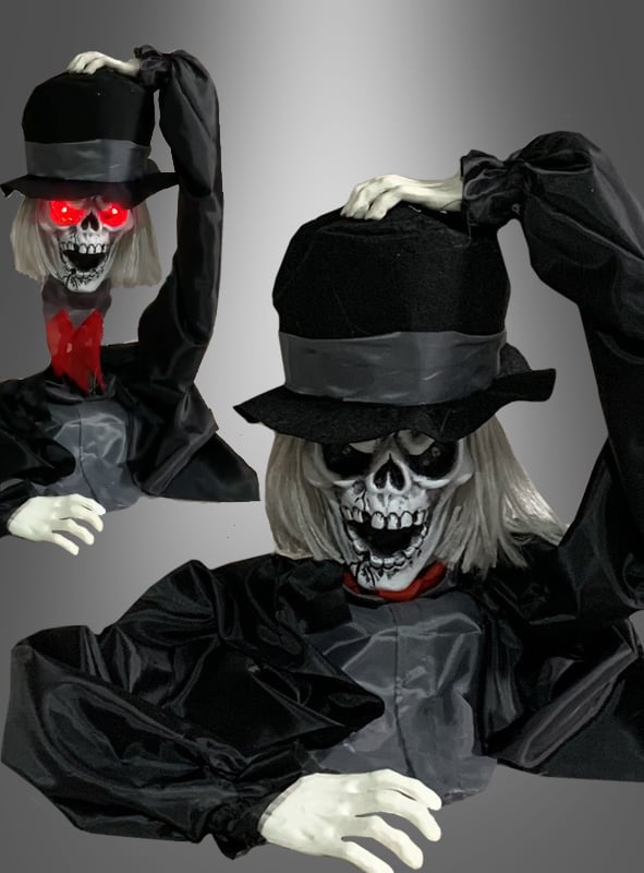 Verleihen Sie Ihrer Halloween-Dekoration mit dem „Friedhof-Skelett 38 cm mit Animation“ einen gruseligen Touch: Dieses animierte Skelett mit schwarzem Hut und Umhang hebt seinen Hut, trägt einen roten Schal und hat weiße Haare. Eine Variante besticht zudem durch leuchtend rote Augen – ein echtes Highlight und ein echter Blickfang für jede gruselige Dekoration!.