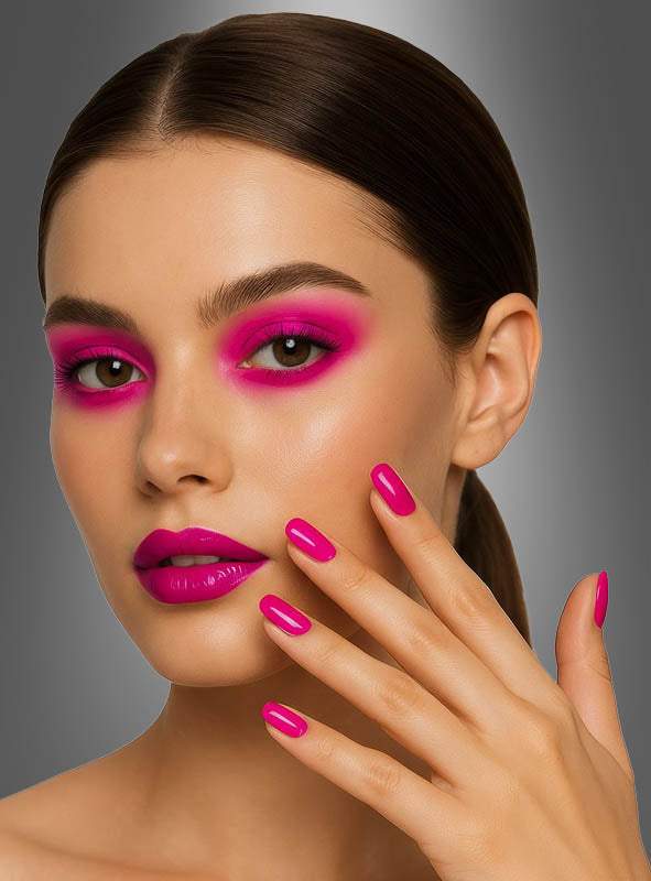 Eine Frau mit nach hinten geglätteten Haaren trägt leuchtend rosa Lidschatten und Lippenstift und berührt ihr Gesicht mit manikürten Fingern, die mit „Neon Pink Nägel selbstklebend 12 Stück“ verziert sind, vor einem grauen Hintergrund mit Farbverlauf.