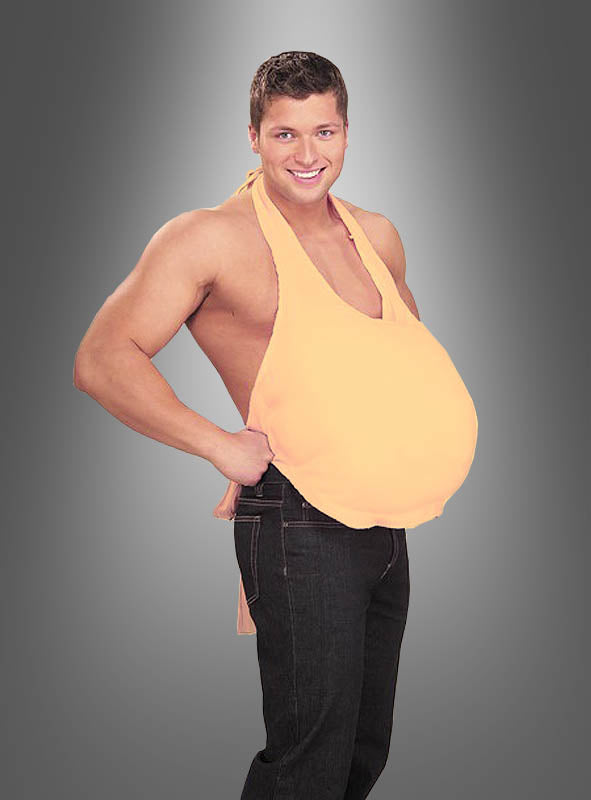 Ein Mann in Jeans und einem pfirsichfarbenen Neckholder-Top posiert vor einem grauen Hintergrund mit Farbverlauf und präsentiert auf humorvolle Weise den „Bierbauch-Attrappe – wattierter Bauch“ – ein naturgetreues, gepolstertes Bauchkostüm, das sich perfekt für lustige Herrenoutfits eignet.