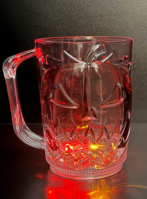 Ein großer Halloween-Kürbisbecher mit LED, 700 ml, strahlt mit rot-gelbem Licht am Boden und zeigt ein geschnitztes Kürbisgesicht auf klarem Glas – der perfekte leuchtende Halloween-Becher, um deiner Feier festlichen Charme zu verleihen.