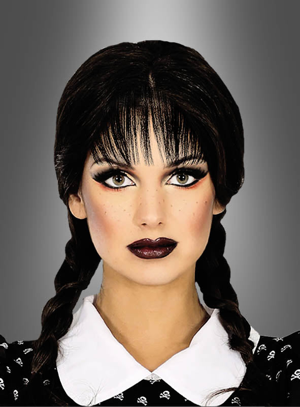 Eine Person mit geflochtenen dunklen Haaren, gestylt mit der „Schwarzen Perücke mit Zöpfen für Erwachsene“, dramatischem Make-up und einem Kleid mit Kragen, posiert vor einem grauen Hintergrund mit Farbverlauf.