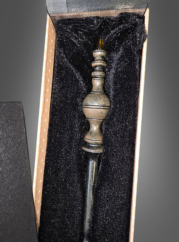 Ein Zauberstab Deluxe in einer Geschenkschachtel mit einem kunstvoll gearbeiteten Griff ruht in einer mit schwarzem Samt ausgekleideten Geschenkbox und weckt Erinnerungen an den legendären Harry-Potter-Zauberstab aus der berühmten Zauberschule.