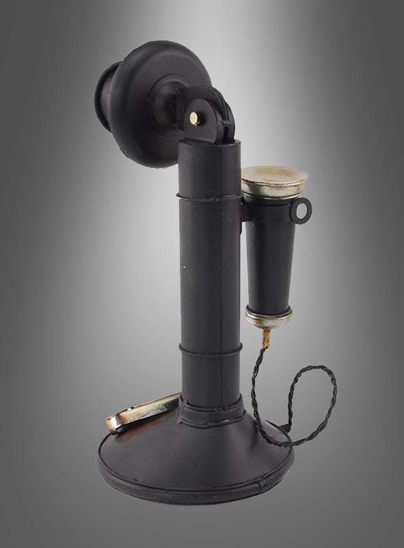 Ein schwarzer Retro-Telefon-Dekokerzenhalter im Stil der 20er Jahre mit drehbarem Sockel, aufrecht stehendem Hörer und fest angebrachtem Ohrstück thront elegant auf einem grauen Hintergrund mit Farbverlauf – ein ideales Stück für eine Vintage-Einrichtung oder jeden retro-inspirierten Raum.