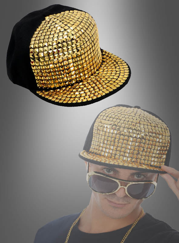 Eine Hip-Hop-Baseballkappe mit goldenen Nieten wird über einer Person präsentiert, die dieselbe Kappe, eine Sonnenbrille und eine Goldkette trägt – vor einem grauen Farbverlaufshintergrund. Ideal für jede 80er-Jahre-Mottoparty oder für alle, die auffällige Accessoires mit goldenen Nieten lieben.