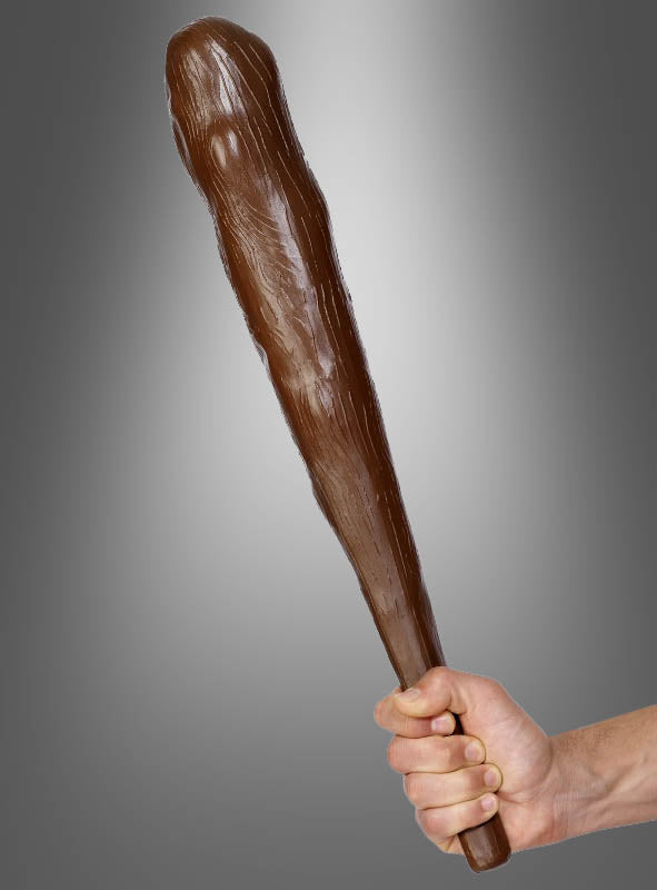 Eine Hand, die die „Keule für Urmensch 50 cm Steinzeit“ hält – ein großes, keulenförmiges, braunes Accessoire, das sich ideal zur Vervollständigung Ihres Steinzeitkostüms eignet oder als perfektes Neandertaler-Accessoire dient –, vor einem grauen Hintergrund mit Farbverlauf.