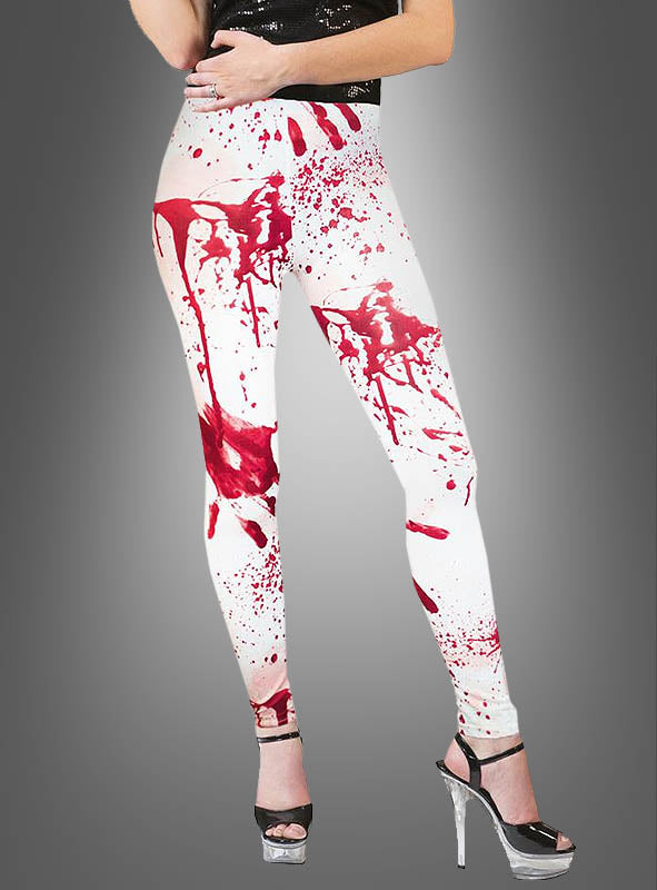 Eine Person, die „Blutige Leggings Damen“ trägt – mit roten Spritzmustern, die an Blut erinnern –, kombiniert diese mit einem schwarzen Oberteil und silbernen High Heels, während sie vor einem grauen Hintergrund mit Farbverlauf steht – damit ist dieses Outfit die perfekte Wahl für ein Zombie-Kostüm auf Ihrer nächsten Halloween-Party.