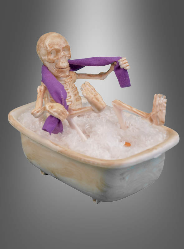 Ein 27 cm großes, animiertes Skelett in der Badewanne, komplett mit einem lila Handtuch, sitzt in einer mit Seifenblasen gefüllten Badewanne vor einem grauen Hintergrund mit Farbverlauf – und sorgt so für die perfekte Halloween-Dekoration.