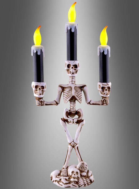 Der „Skelett“-Kerzenleuchter (36 cm) mit LED-Kerzen besteht aus einem Kerzenleuchter in Form eines Skeletts, der drei schwarze LED-Kerzen mit künstlichen Flammen trägt und auf einem Sockel steht, der mit Totenköpfen und einem Grabstein mit der Aufschrift „RIP“ verziert ist – damit ist er der perfekte Halloween-Kerzenhalter, um Ihrer Dekoration einen gruseligen Touch zu verleihen.