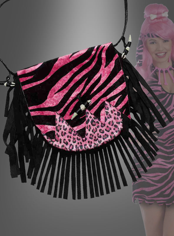 Zu sehen ist eine Handtasche mit rosa-schwarzen Zebrastreifen, schwarzen Fransen und Akzenten im Leopardenmuster; im Hintergrund rundet eine passend gekleidete Person den modernen Urmensch-Look ab.