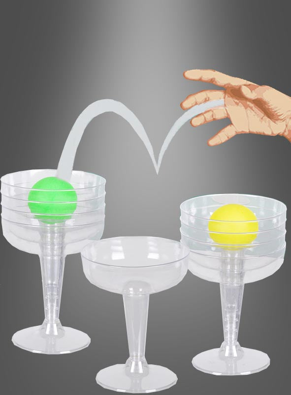 Eine Hand wirft einen grünen Tischtennisball in einen Plastikbecher, während ein gelber Ball in einem anderen Becher neben zwei leeren Bechern liegt – damit ist „Trinkspiel für Mädels Prosecco Pong“ die perfekte Ergänzung für deinen nächsten Junggesellinnenabschied.