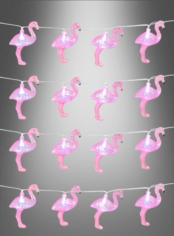 Die „Lichterkette 140 cm Flamingo Sommerparty“ – eine Lichterkette in Form von rosa Flamingos, die sich perfekt für Ihre nächste Sommerparty eignet – hängt vor einem grauen Hintergrund mit Farbverlauf.