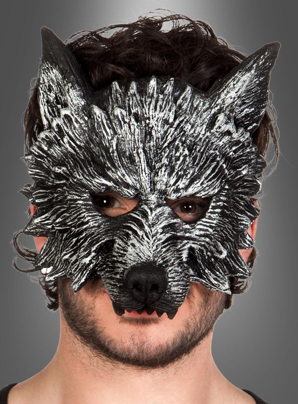 Vor einem grauen Hintergrund ist eine Person in einem schwarz-weißen Wolfskostüm zu sehen, die die auffällige Wolf-Werwolf-Halbmaske trägt, die sich durch spitze Ohren und sichtbare Augen auszeichnet.