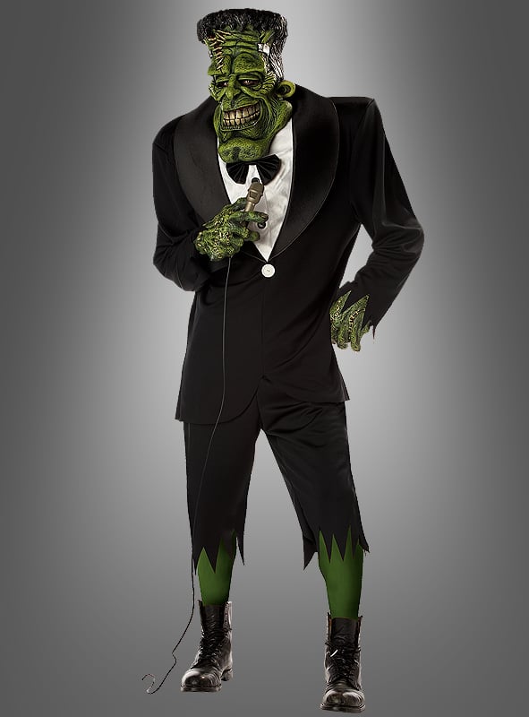 Im „Big Franky Monster“-Kostüm mit übergroßer Maske (Herrenkostüm L–XL) als Frankensteins Monster strahlt eine Person Selbstbewusstsein aus, während sie ein Mikrofon in der Hand hält und vor einem grauen Hintergrund posiert – perfekt für alle, die in diesem authentischen Franky-Monster-Kostüm Eindruck hinterlassen möchten.