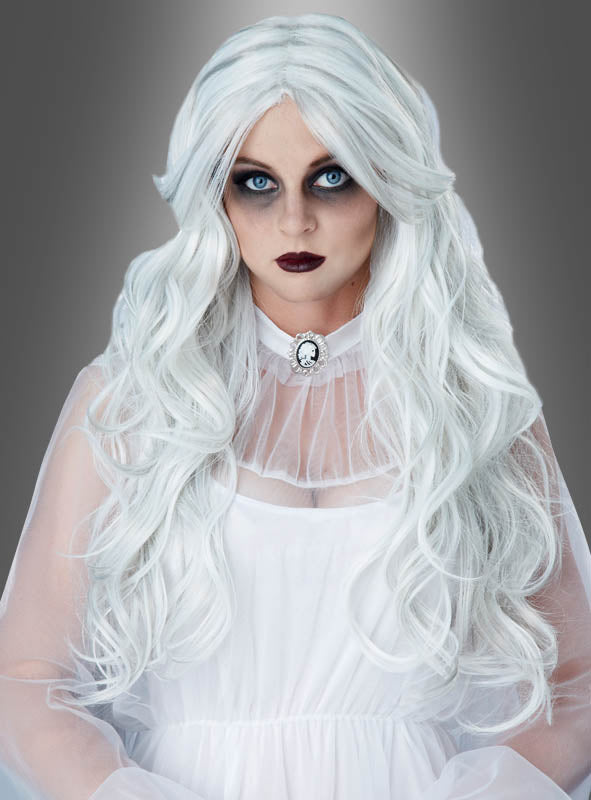 Eine Person mit langen weißen Haaren, die zur „Weißen Geisterperücke“ frisiert sind, dramatischem dunklem Augen-Make-up und dunklem Lippenstift trägt ein durchscheinendes weißes Kleid mit einer Kamee-Brosche und posiert vor einem neutralen grauen Hintergrund – ein eindringlich eleganter Look, der sich perfekt für jede Halloween-Veranstaltung oder jedes „Geisterdamen“-Kostüm mit der „Weißen Geisterperücke“ eignet.