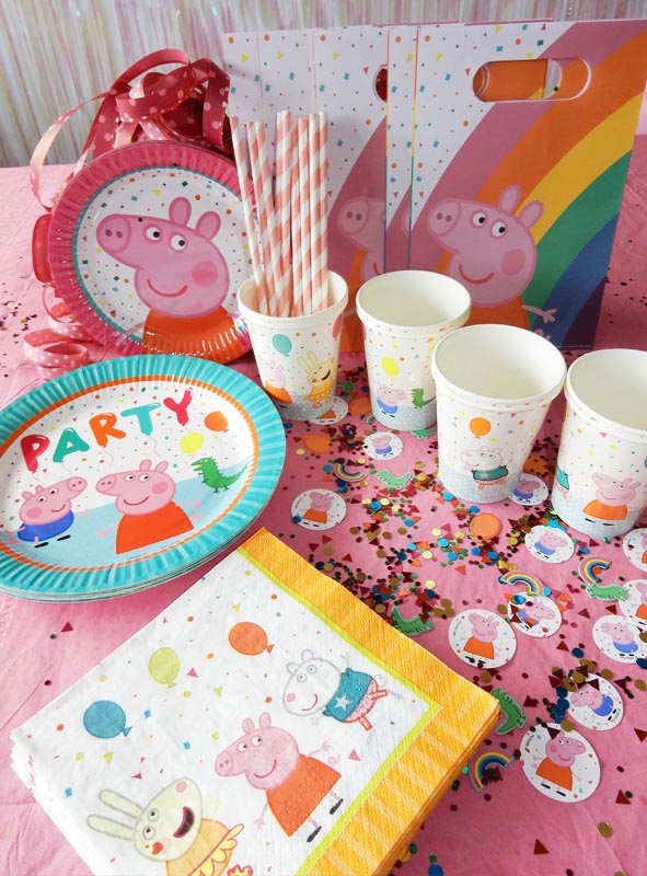 Aber sicher! Hier ist der überarbeitete Satz unter Verwendung der angegebenen Produktdaten: Partyzubehör zum Thema „Peppa Pig“, arrangiert auf einem rosa Tisch, darunter Peppa-Pig-Tischdekoration wie Teller, Becher, Servietten, Geschenktüten, Papierstrohhalme und „Peppa Wutz“-Konfetti-Streuteile mit Comicfiguren und Luftballons.