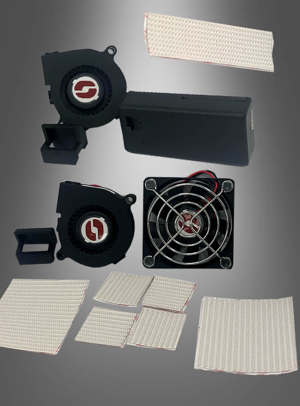 Ein Lüftersystem für Masken und Helme, bestehend aus Computer-Lüftern und mehreren rechteckigen Wärmeleitpads, ist vor einem grauen Hintergrund mit Farbverlauf abgebildet.