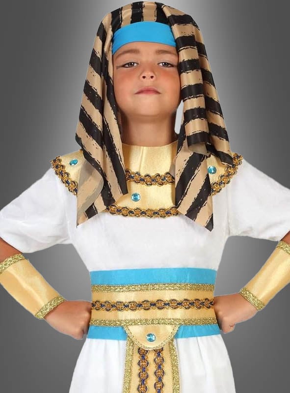 Ein Kind im auffälligen ägyptischen Pharao-Kinderkostüm mit goldenen und blauen Akzenten und einer klassischen gestreiften Kopfbedeckung steht selbstbewusst mit den Händen in die Hüften gestemmt vor einem grauen Hintergrund – ideal für den Kinderfasching oder fantasievolle Verkleidungsspiele.