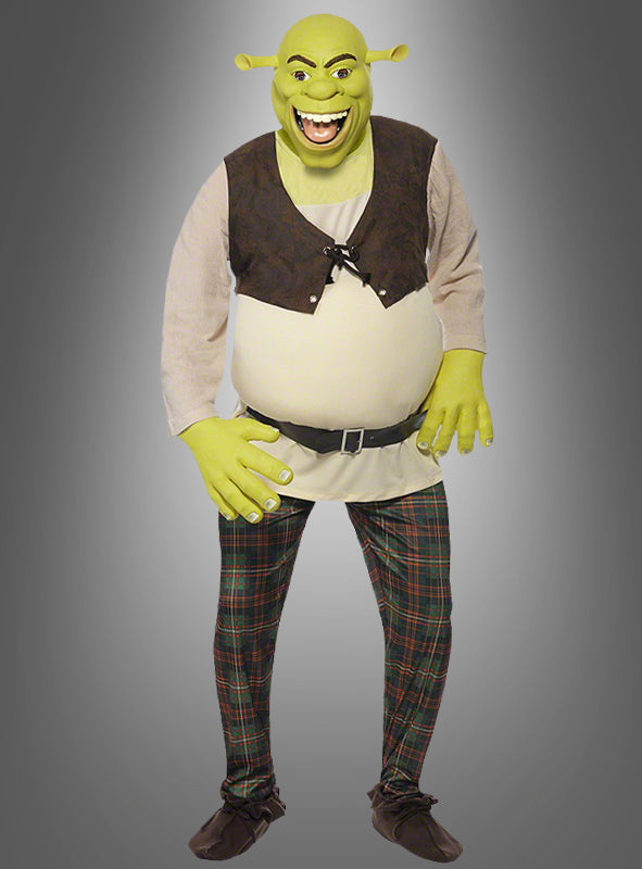 Eine Person im Shrek-Ogerkostüm für Erwachsene – mit grüner Schminke, einer braunen Weste, einer karierten Hose und Shrek-Ohren aus Schaumstoff – steht vor einem grauen Hintergrund mit Farbverlauf – perfekt für alle, die bei ihrer nächsten Shrek-Kostümparty einen authentischen Ogerkostüm-Look für Herren suchen.
