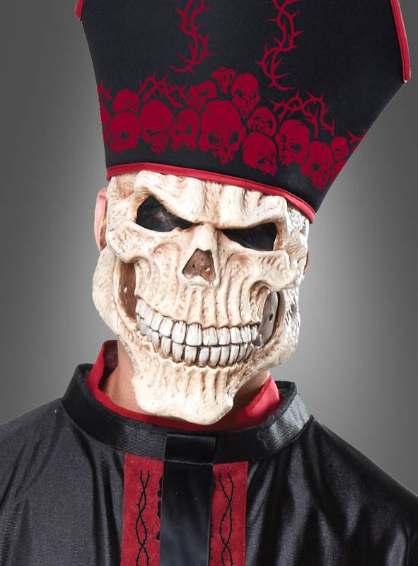 Eine Person im „Zombie Priester“-Herrenkostüm – bestehend aus einer großen Totenkopfmaske, einem schwarz-roten Kostüm und einem hohen Hut mit Totenkopfmotiven – posiert vor einem schlichten grauen Hintergrund. Dieses auffällige Outfit ist die ideale Wahl für alle, die ein beeindruckendes Halloween-Kostüm für Herren suchen oder die unheimliche Atmosphäre eines mittelalterlichen Horrorkostüms einfangen möchten.