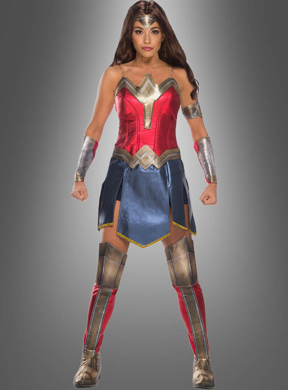 Eine Person, die das Deluxe-Wonder-Woman-Kostüm trägt, steht mit leicht angewinkelten Armen und geballten Fäusten nach vorne gerichtet und verkörpert vor einem schlichten grauen Hintergrund die Stärke der legendären DC-Superheldin.