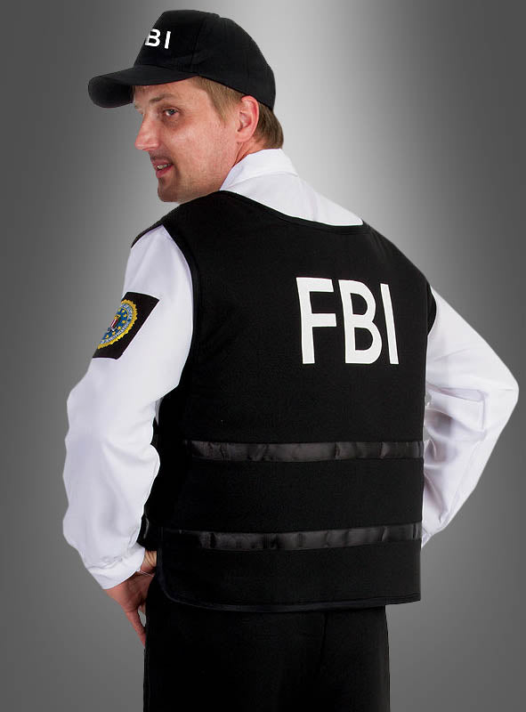 Ein Mann, der das FBI-Herren-Komplettkostüm trägt, steht mit dem Rücken zur Kamera, wodurch der auffällige FBI-Schriftzug auf seiner Weste vor einem neutralen grauen Farbverlauf besonders gut zur Geltung kommt – die perfekte Inspiration für alle, die einen authentischen Agenten-Look suchen.
