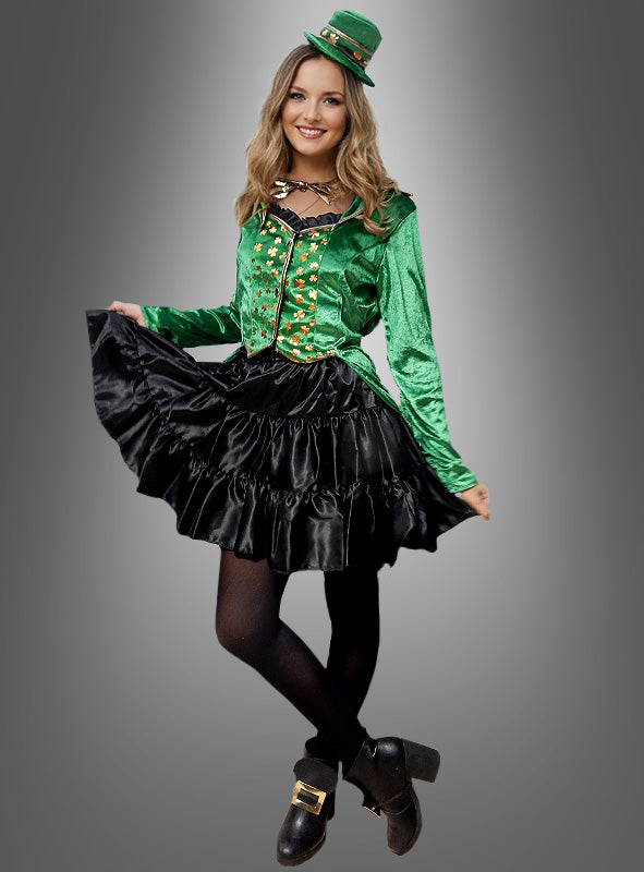 Eine Frau trägt das „Sexy Kobold“-Kostüm für Damen, bestehend aus einem grünen Karnevalskostüm mit grüner Jacke, schwarzem Rock, schwarzer Strumpfhose und einem kleinen grünen Hut – ein auffälliger Look, der sich perfekt für Feierlichkeiten zum St. Patrick’s Day eignet. Das Foto zeigt sie vor einem schlichten grauen Hintergrund.