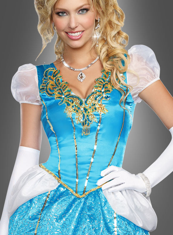 Eine Frau, die das „Märchenhaftes Ballkleid Prinzessin“ trägt – ein bezauberndes blaues Ballkleid mit goldenen Verzierungen –, kombiniert mit weißen Handschuhen und elegantem Schmuck, posiert anmutig vor einem grauen Hintergrund.