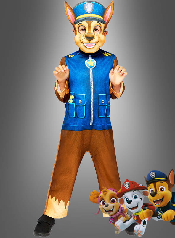 Ein Kind, das das Chase-Kostüm von „Paw Patrol“ mit Maske trägt, steht vor einem grauen Hintergrund, während in der rechten unteren Ecke drei Zeichentrickfiguren aus „Paw Patrol“ zu sehen sind – damit ist dieses Kostüm perfekt für jeden kleinen Fan des heldenhaften Polizisten-Kinderkostüms.