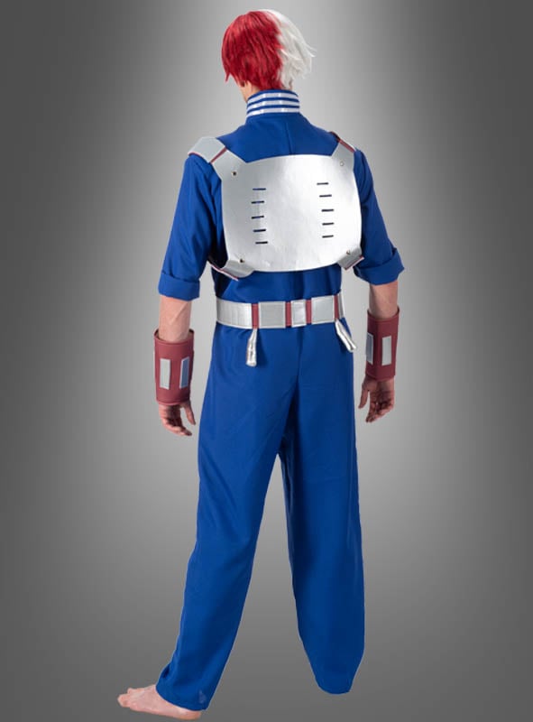Eine Person im Shoto-Todoroki-Kostüm für Erwachsene aus „My Hero Academia“ – bestehend aus einem blauen Overall, roten und weißen Haaren, einer metallischen Rückenplatte und Handgelenkschützern –, die barfuß mit dem Rücken zur Kamera steht.
