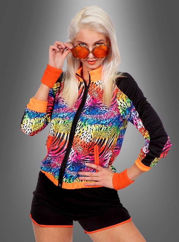 Eine Frau präsentiert den Trainingsanzug „Sommer Trainingsanzug Animal Print“ – eine farbenfrohe Jacke mit Tierprint –, kombiniert mit schwarzen Shorts mit orangefarbenen Paspeln, orangefarbenen Armbändern und einer orange getönten Sonnenbrille. So entsteht ein auffälliger Look, der sich ideal für ein 80er-Jahre-Kostüm oder ein Damen-Party-Set eignet, während sie selbstbewusst vor einem grauen Hintergrund mit Farbverlauf posiert.