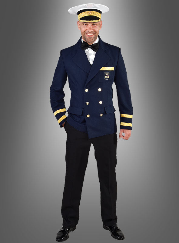 Ein Mann steht lächelnd da und trägt eine marineblaue Kapitän-Kostümjacke für Herren mit goldenen Streifen an den Ärmeln, dazu eine schwarze Hose, schwarze Schuhe und einen weißen Hut vor einem grauen Hintergrund – ein ideales Outfit für maritime Veranstaltungen oder als authentisches Kapitänskostüm.