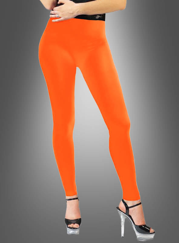 Eine Person trägt die „Blickdichte Leggings Neon im 80er-Jahre-Look“ in leuchtendem Orange, kombiniert mit schwarzen Sandalen mit hohen Absätzen, und steht vor einem grauen Hintergrund mit Farbverlauf – ein auffälliger Look im Stil der 80er Jahre.