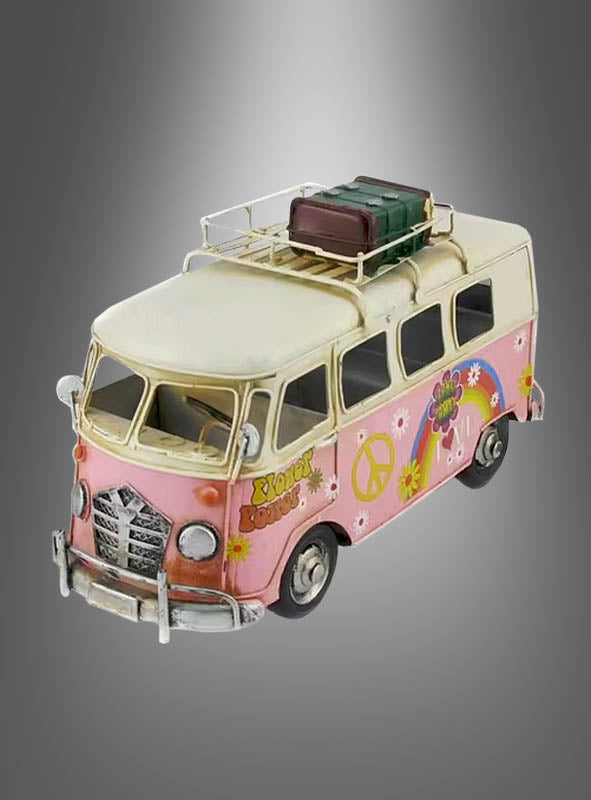 Ein Modell der „Hippie-Bus Blechauto 70er-Party-Deko“, bestehend aus einem Oldtimer-Van in Rosa und Creme, verziert mit Peace-Symbolen, Blumenmotiven und Gepäck auf dem Dach, das an einen klassischen Hippie-Bus erinnert, vor einem grauen Hintergrund mit Farbverlauf.
