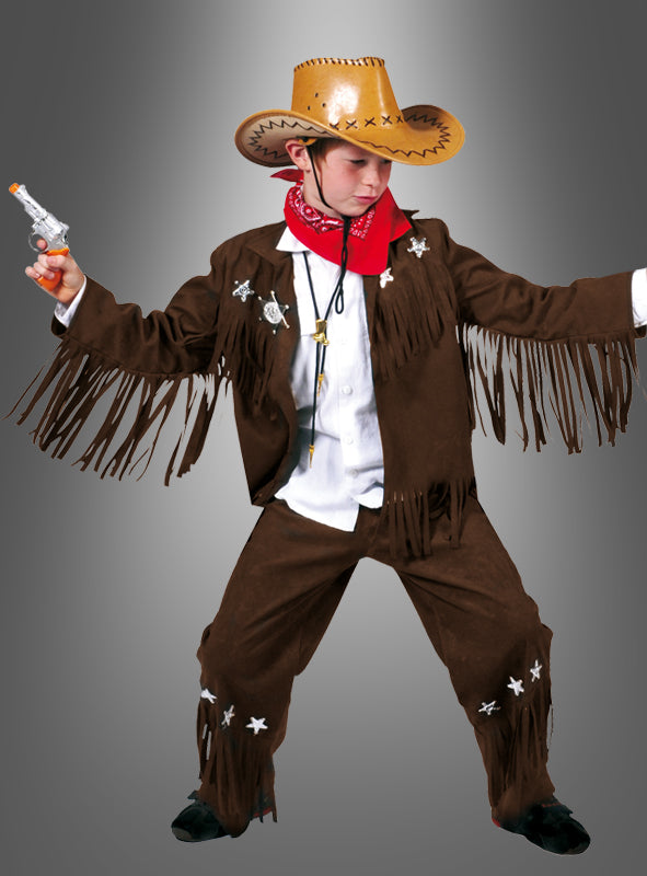 Ein Kind trägt das Cowboy-Bud-Kinderkostüm mit Hut, rotem Halstuch, einer Jacke und einer Hose mit Fransen im Wildleder-Look sowie einer Spielzeugpistole und posiert vor einem grauen Hintergrund.
