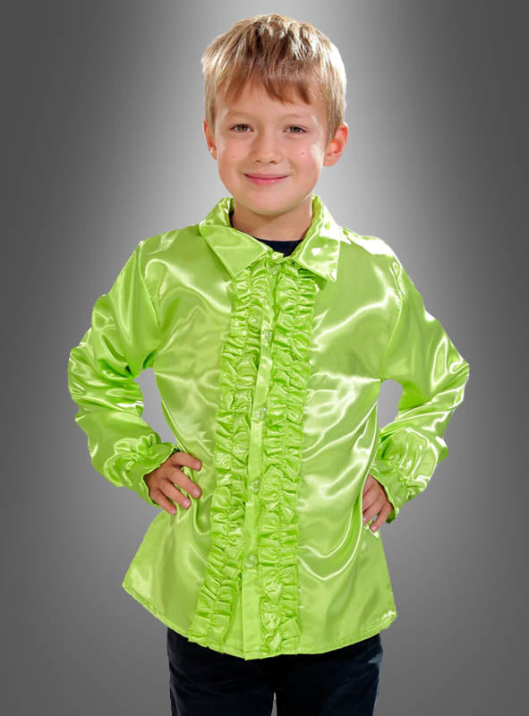 Ein kleiner Junge, der ein glänzendes, leuchtend grünes Rüschenhemd für Kinder in verschiedenen Farben trägt, steht mit den Händen in die Hüften gestemmt vor einem grauen Hintergrund mit Farbverlauf – perfekt für jedes 70er-Jahre-Kostüm oder jedes Disco-Party-Outfit.