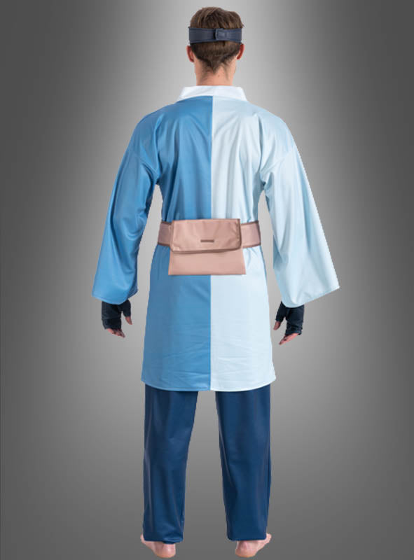 Eine Person, die barfuß ist und von hinten gezeigt wird, trägt das „Mitsuki-Kostüm für Erwachsene“ aus dem Anime „Boruto“ – bestehend aus einer blauen, geschlitzten Robe, einer marineblauen Hose, schwarzen Handschuhen, einer hellbraunen Gürteltasche und einem Stirnband – vor einem grauen Hintergrund mit Farbverlauf.