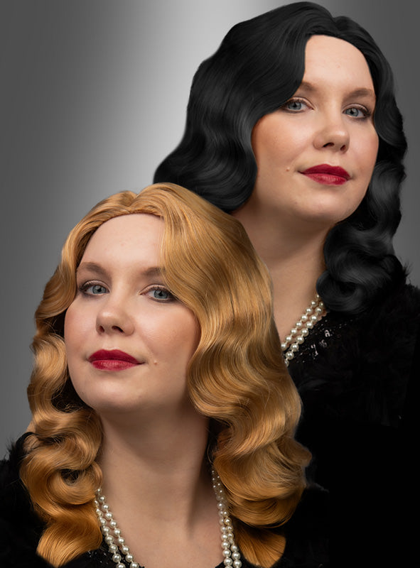 Zwei Frauen mit welligem, schulterlangem Haar – die eine trägt die „20er Jahre Premium Wasserwelle Charlotte“-Perücke in Schwarz, die andere eine dunkelblonde Perücke – sind in schwarze Outfits gekleidet, tragen roten Lippenstift und Perlenketten und posieren elegant vor einem grauen Hintergrund mit Farbverlauf.