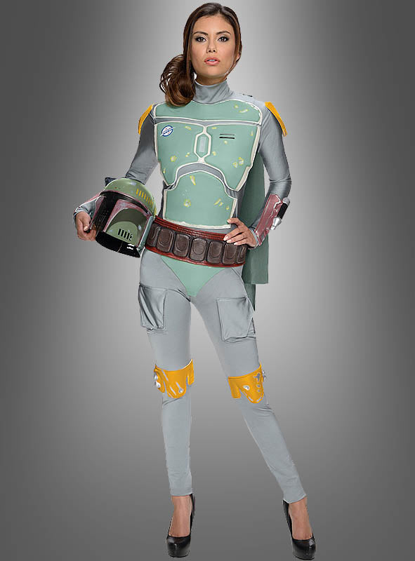 Eine Person in einem grün-grauen Mandalorianer-Kostüm, die einen Helm in der Hand hält und vor einem schlichten Hintergrund mit Farbverlauf steht – perfekt für Fans, die auf der Suche nach dem Boba-Fett-Overall für Damen sind.